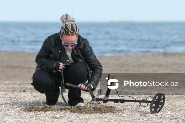 Metal detektoru ilə Xəzər sahilində dəyərli əşyalar axtaran Svetlana Kazımova