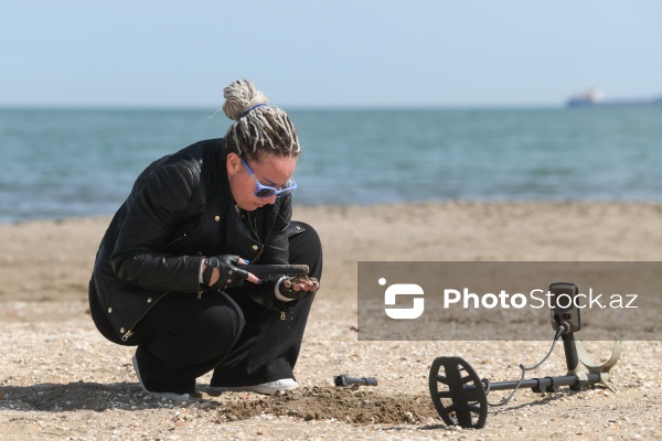 Metal detektoru ilə Xəzər sahilində dəyərli əşyalar axtaran Svetlana Kazımova